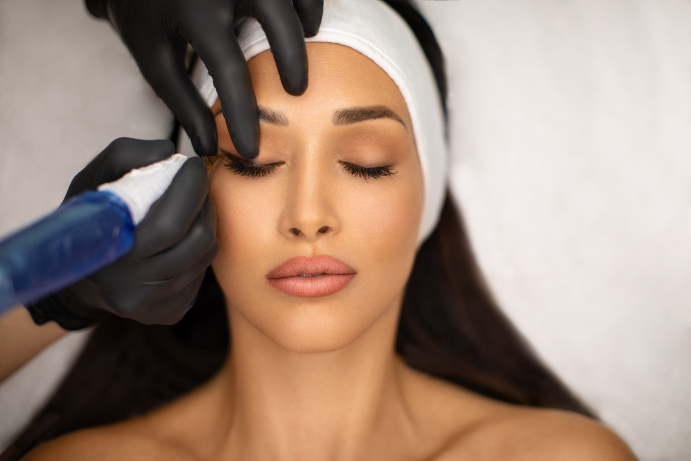 Beautiful young woman receiving permanent make up